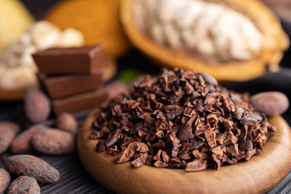 cocoa pods, beans and powder on wooden table, top view USDA, EU and Halal Certified cocoa nibs