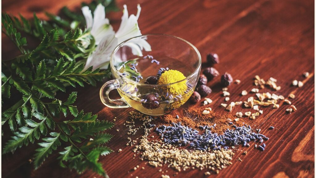 A glass cup of herbal infusion on a wooden table