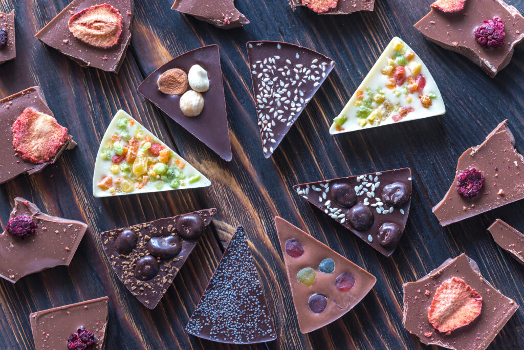 Artisanal chocolate bark with toppings on a wooden surface