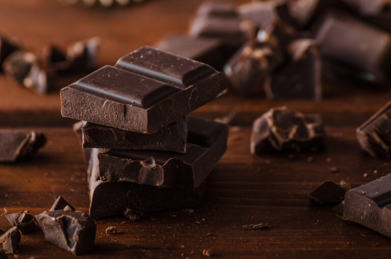 Dark chocolate pieces on a wooden table